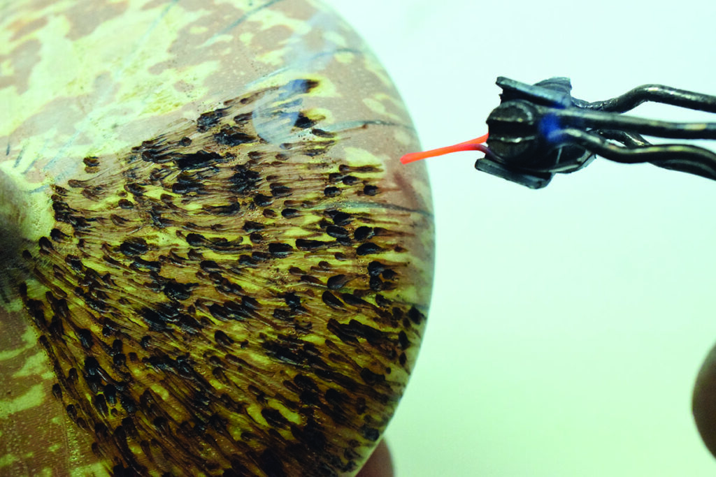 Electric probe testing a painted surface close-up.