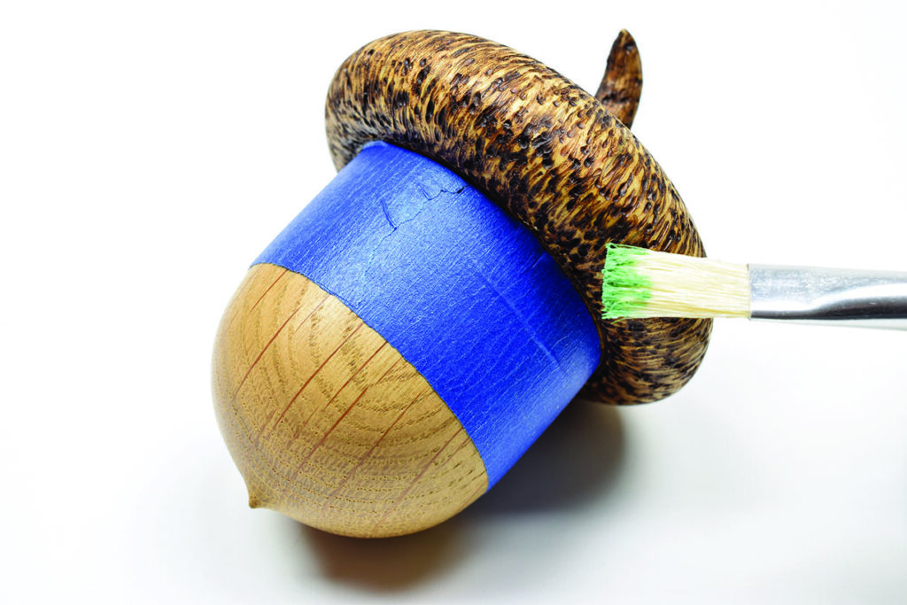 Blue acorn being painted green