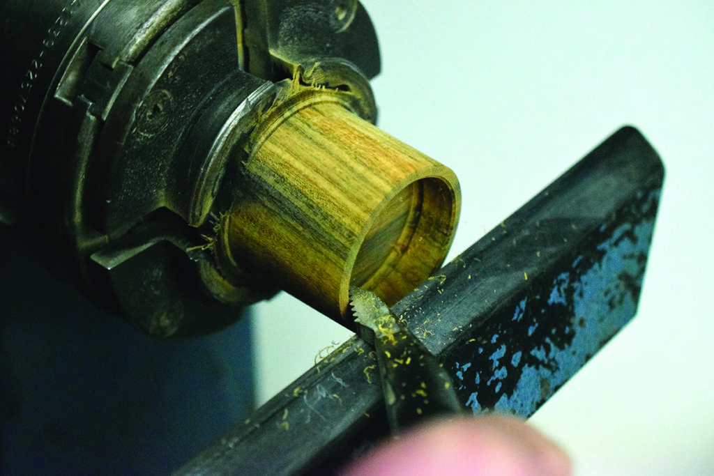 Woodturning a cylinder on lathe machine.