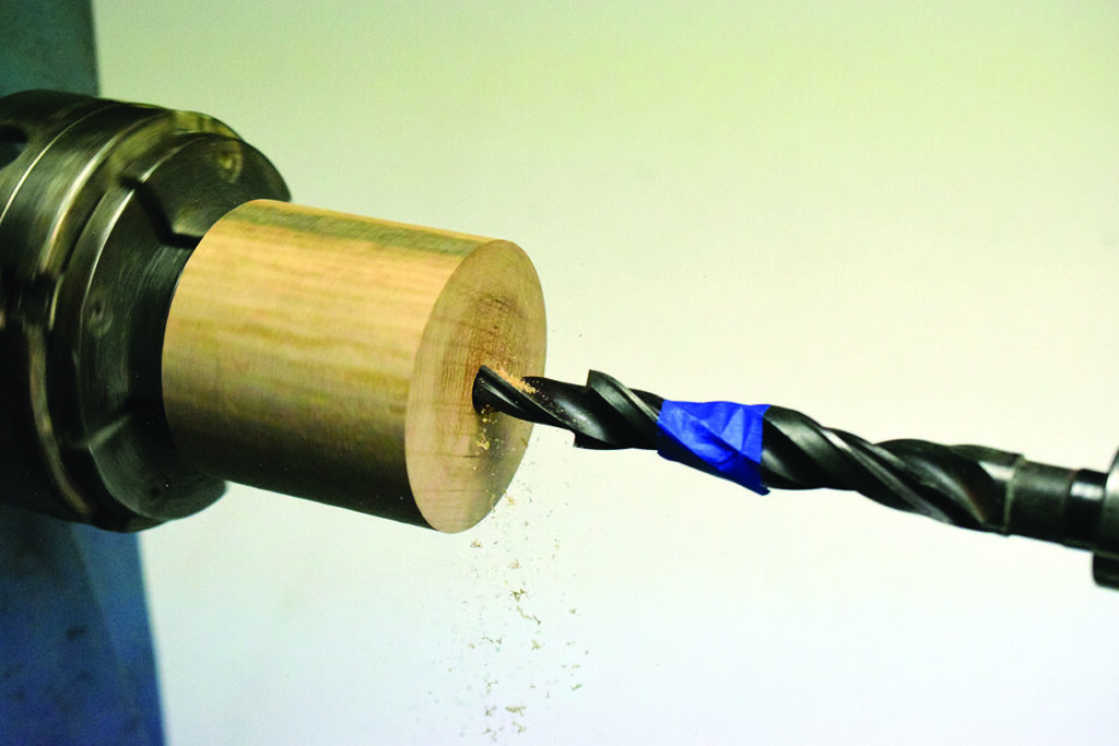 Drill machining a wooden cylinder on lathe