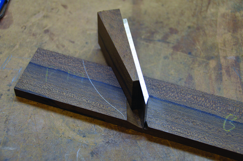 Wooden dovetail joint close-up on workbench.