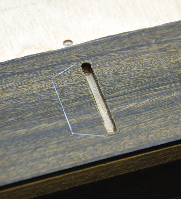 Close-up of wood joint cutout on panel surface.