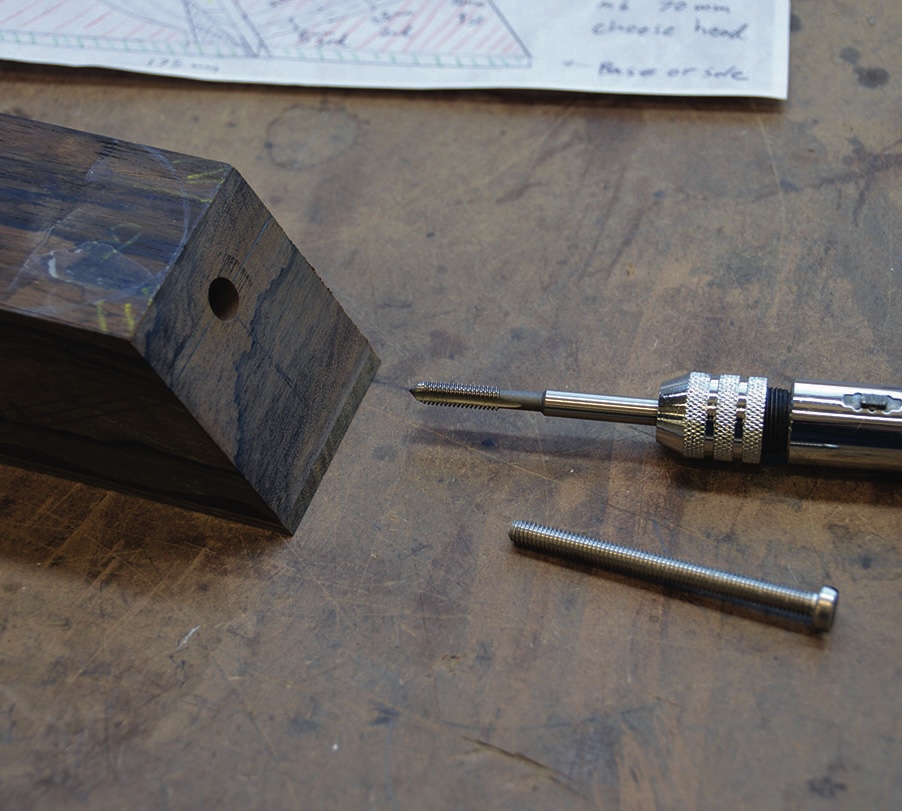 Wood crafting tool and screws on a workbench.