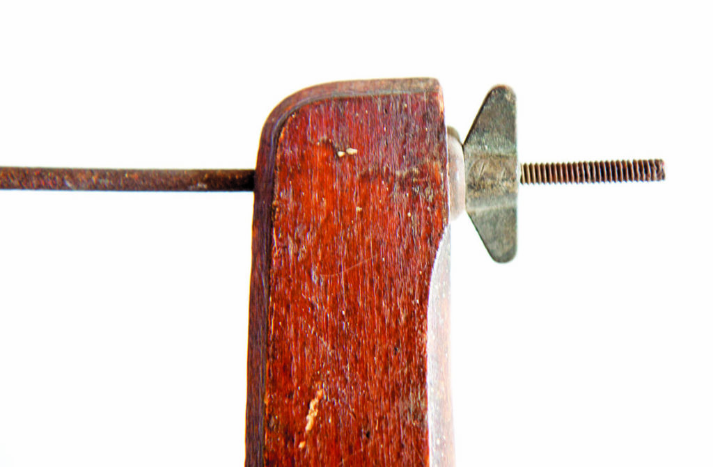 Close-up of vintage wooden clamp with threaded wing nut