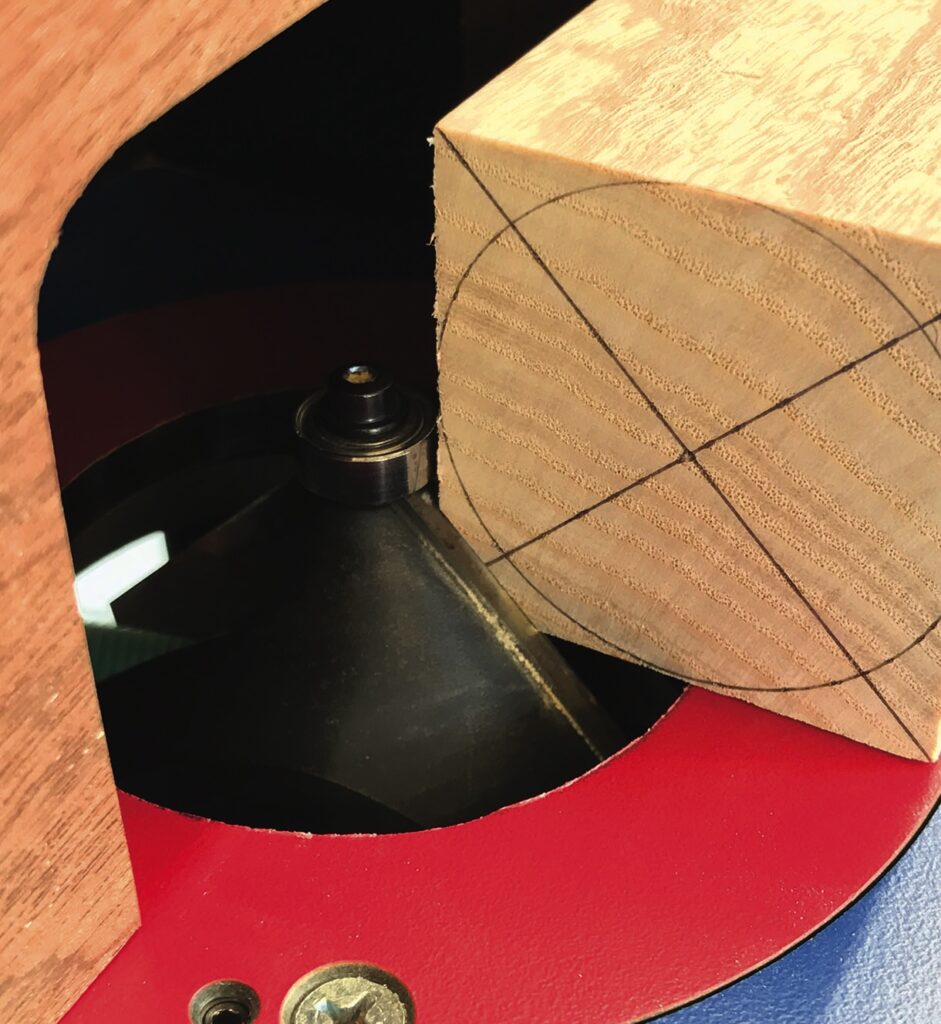 Wood block on a lathe for shaping.