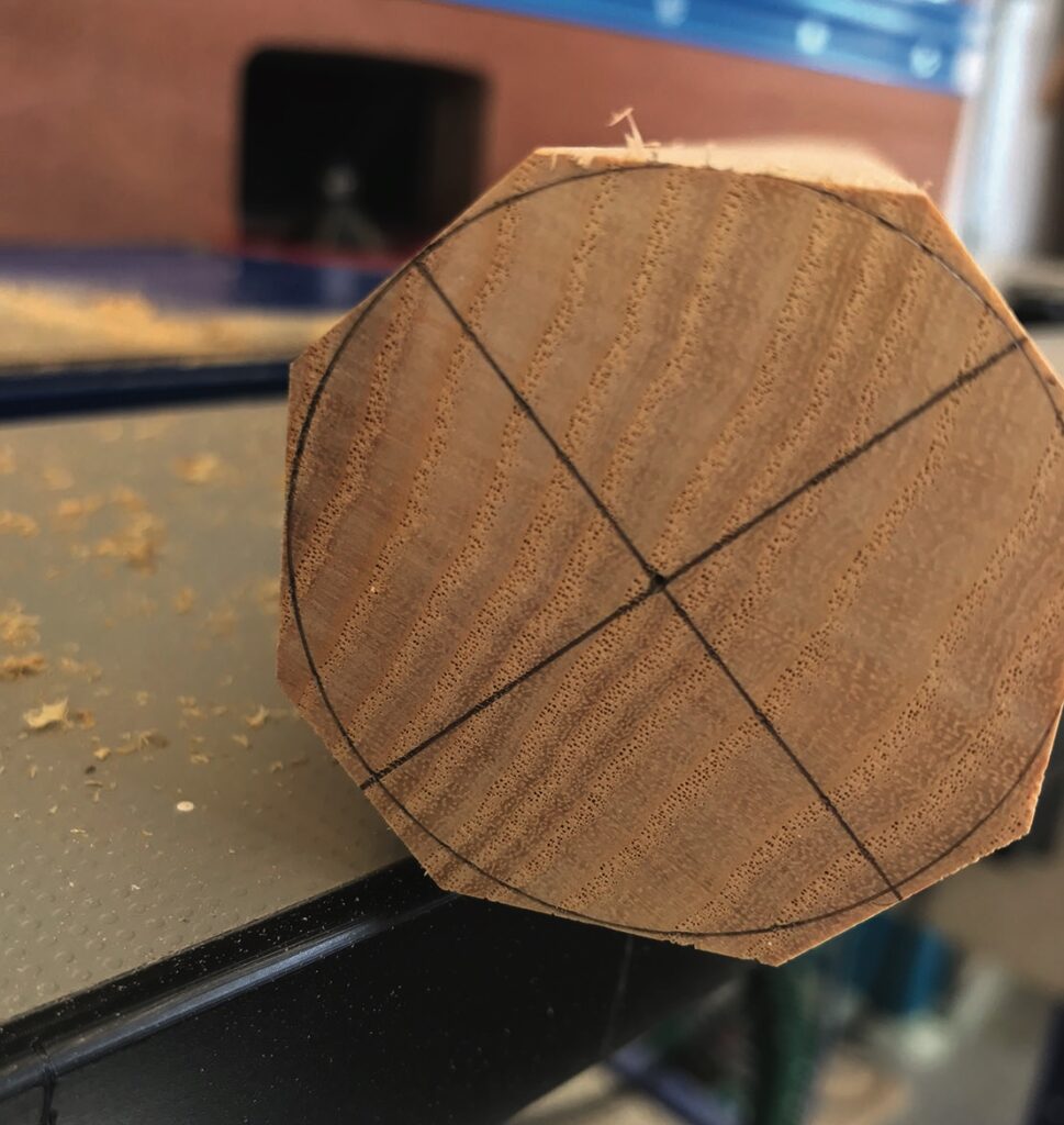 Close-up of marked wooden dowel end on workbench.