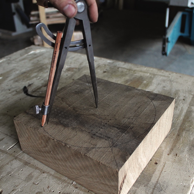 Drawing circle on wood with compass tool.