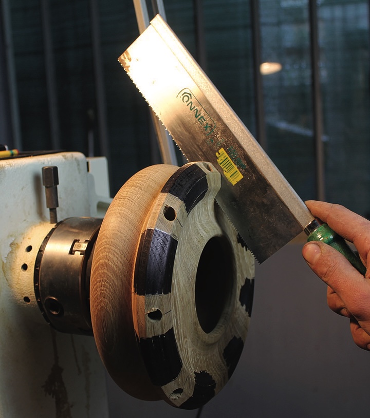 Cutting woodwork disc on lathe with saw