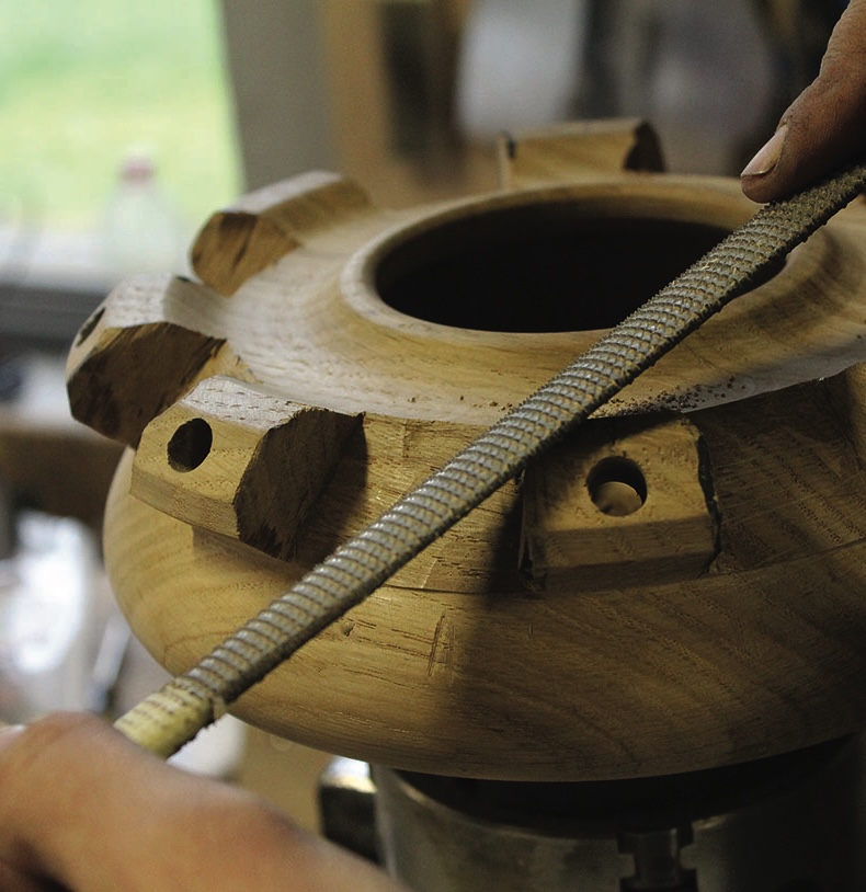 Hand crafting intricate wooden sculpture piece.