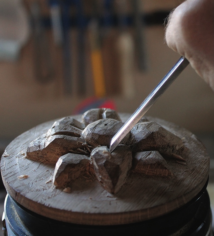 Wood carving with chisel in workshop