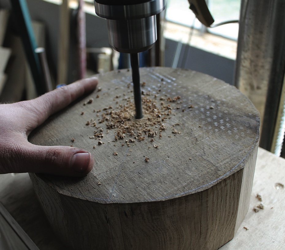 Hand drilling a hole in wooden block.