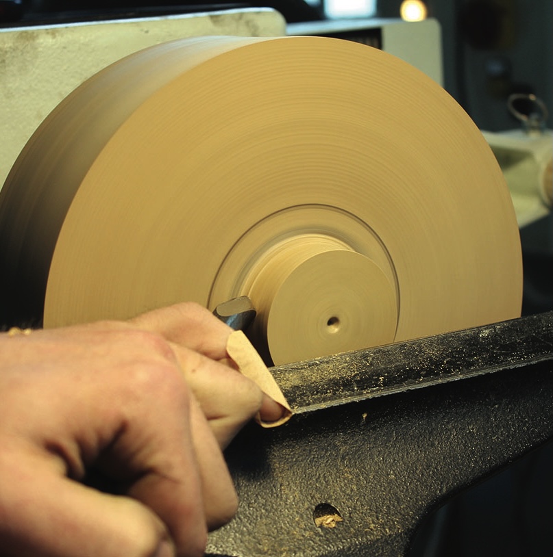 Woodturning with lathe and chisel in workshop.