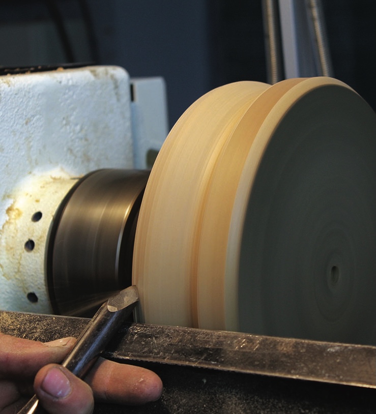 Person using lathe to shape wooden object.