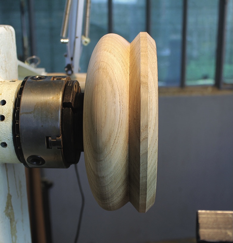 Wooden bowl on lathe in workshop.