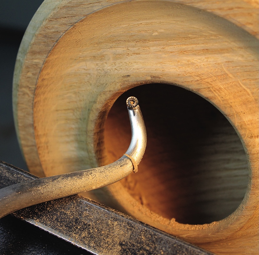 Woodturning tool shaping wooden bowl interior