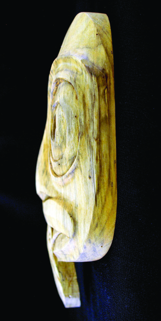 Side view of an elongated pale carved figurine