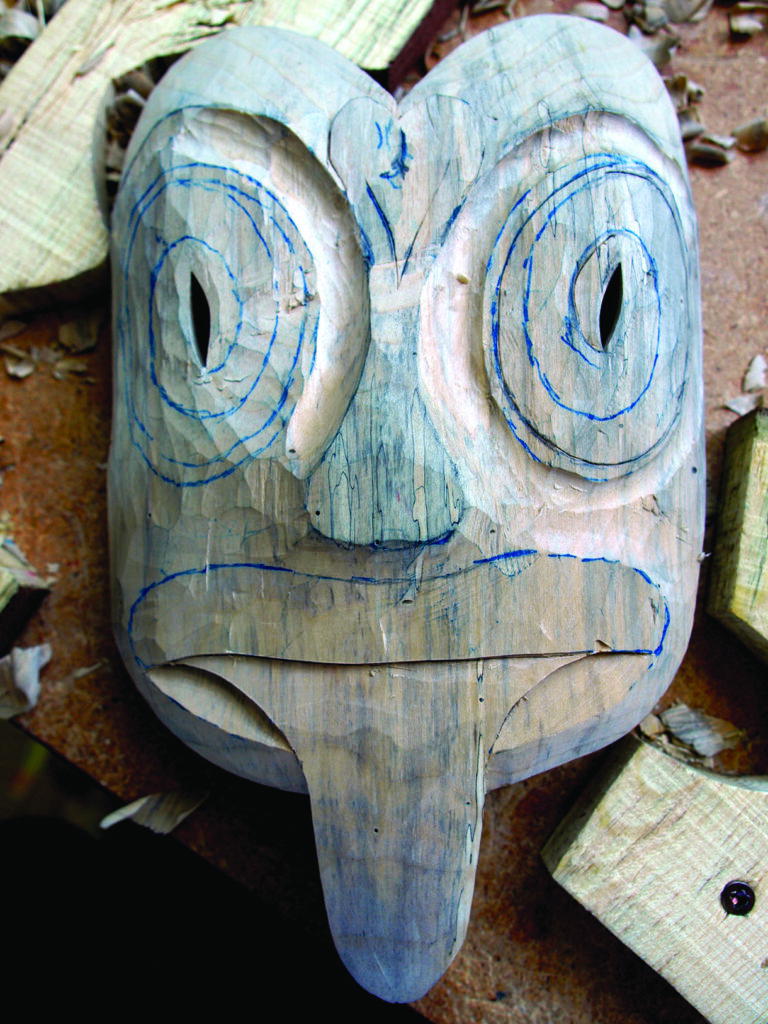 Hand-carved wooden mask with blue facial markings