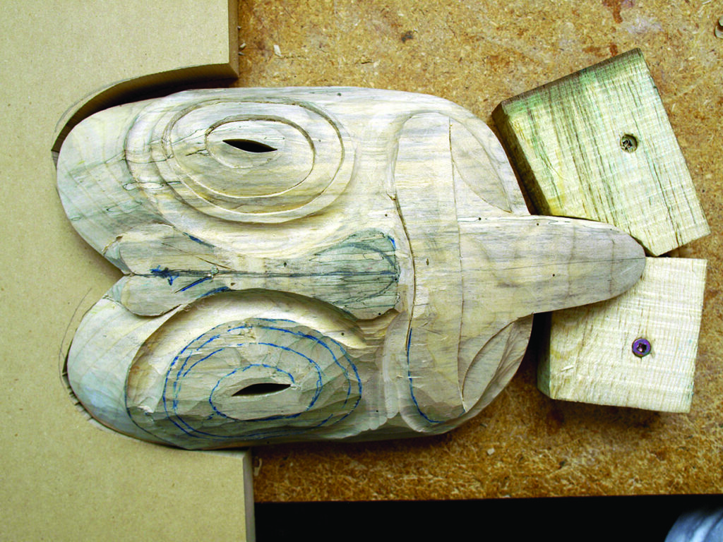 Partially carved wooden frog sculpture on workbench