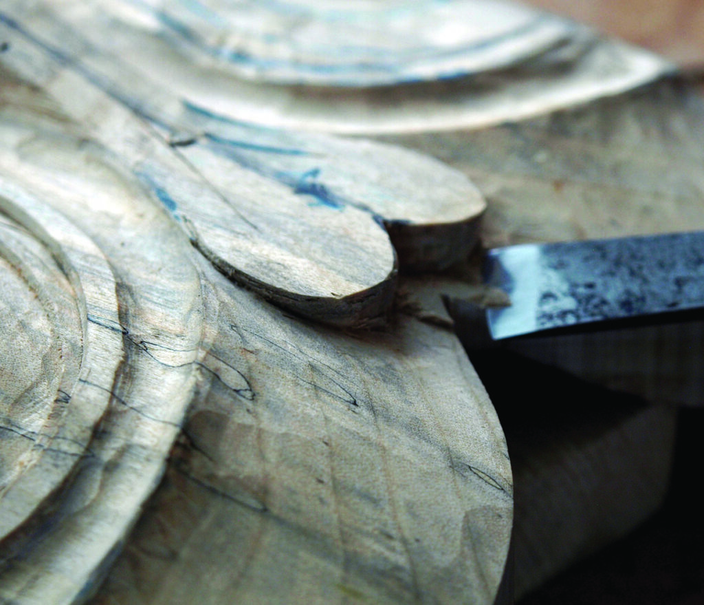 Close-up of a chisel carving a wooden sculpture