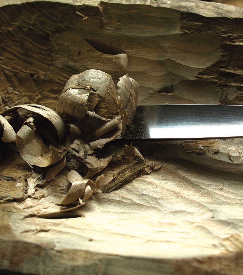 Hand plane shaving wood in a workshop