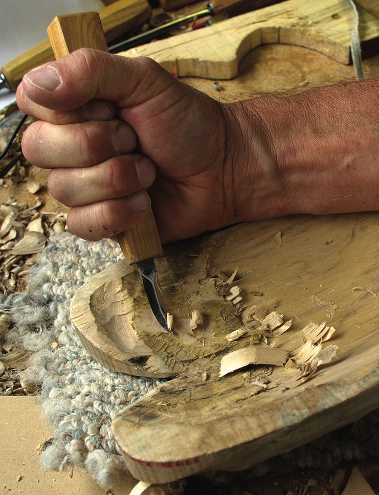 Woodworker carving a wooden bowl with a gouge