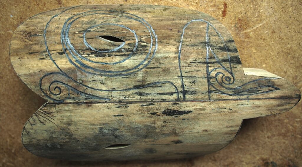 Hand-drawn snail design on weathered wooden object