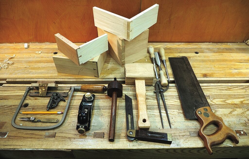 Woodworking tools and dovetail-jointed boxes on workbench