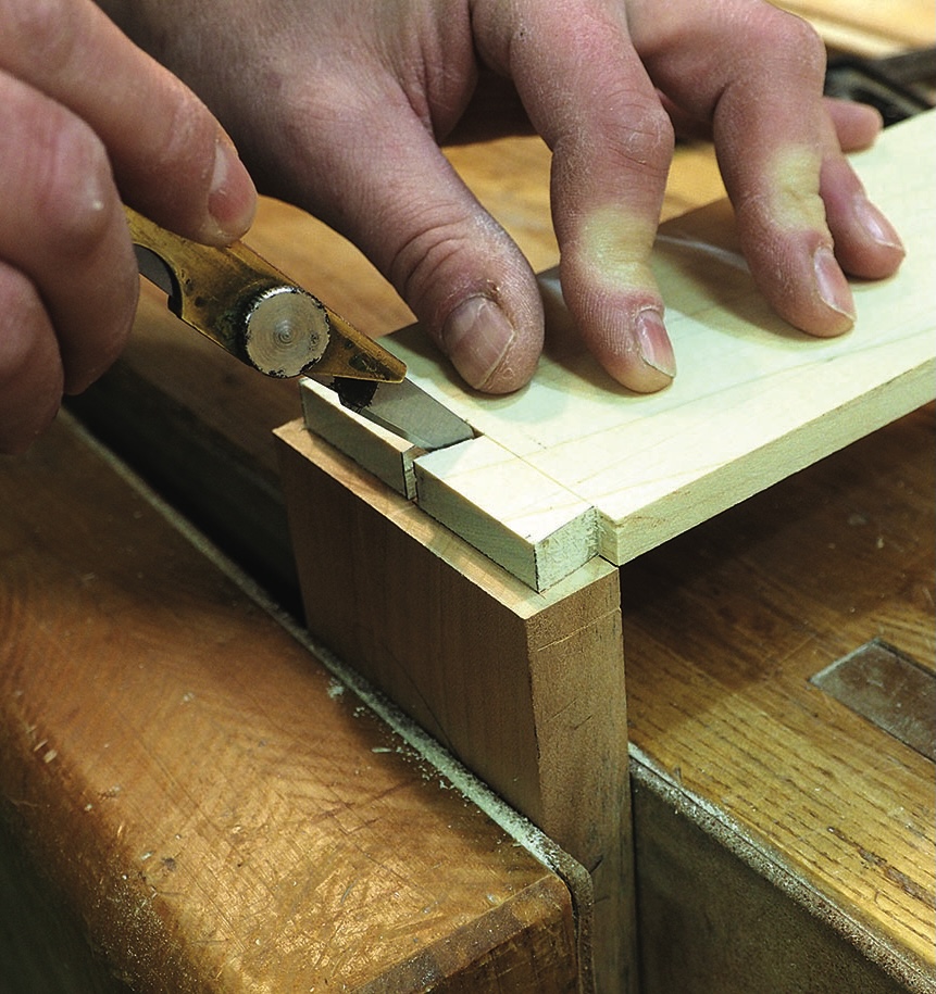Woodworker cutting dovetail joint with marking knife