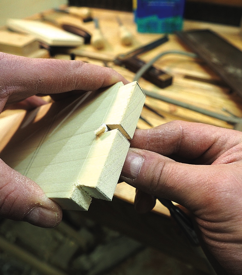Hands holding a wooden mitre joint sample