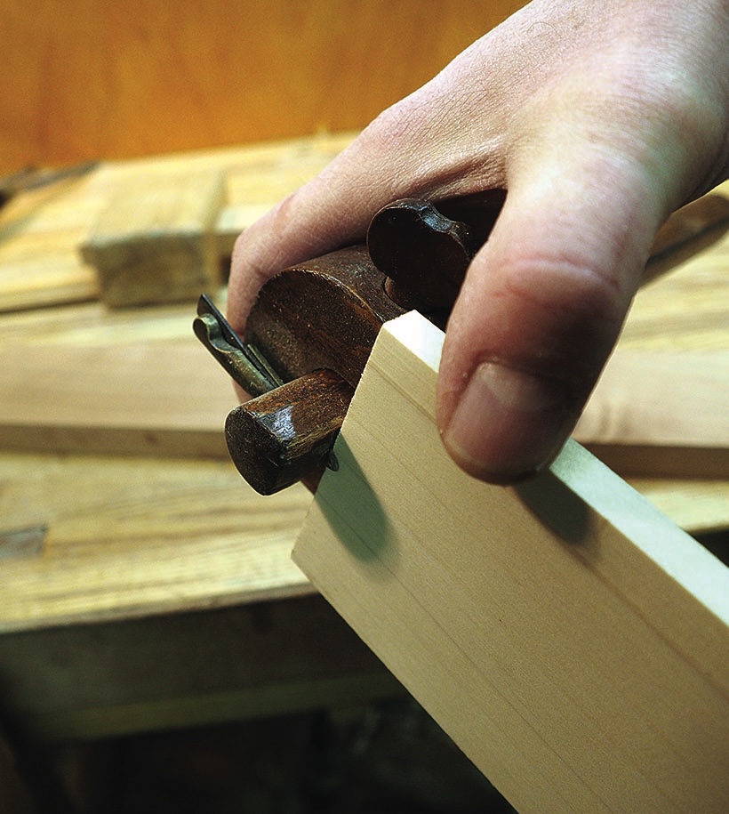 Hand using a hand plane to shape timber