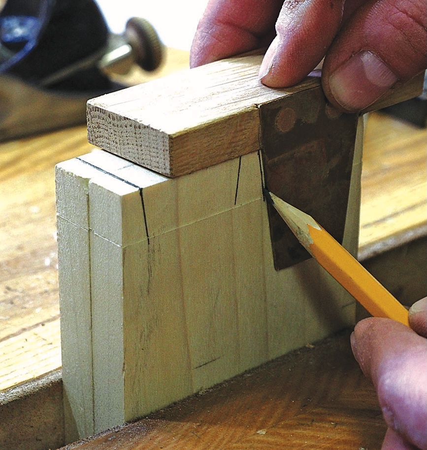 Woodworker marking timber with a try square and pencil