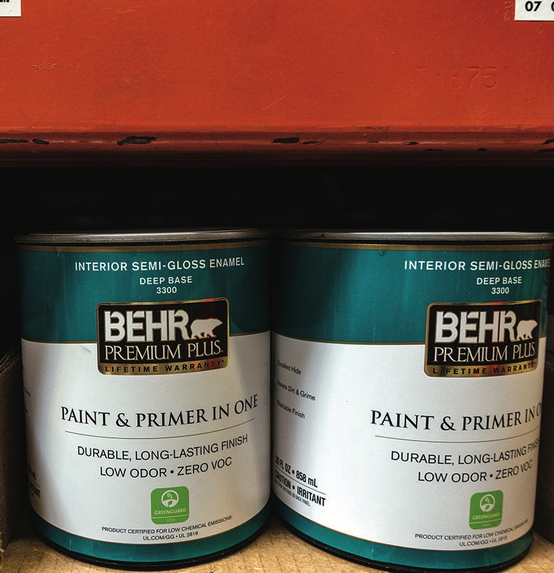 Behr Premium Plus paint cans on shelf.