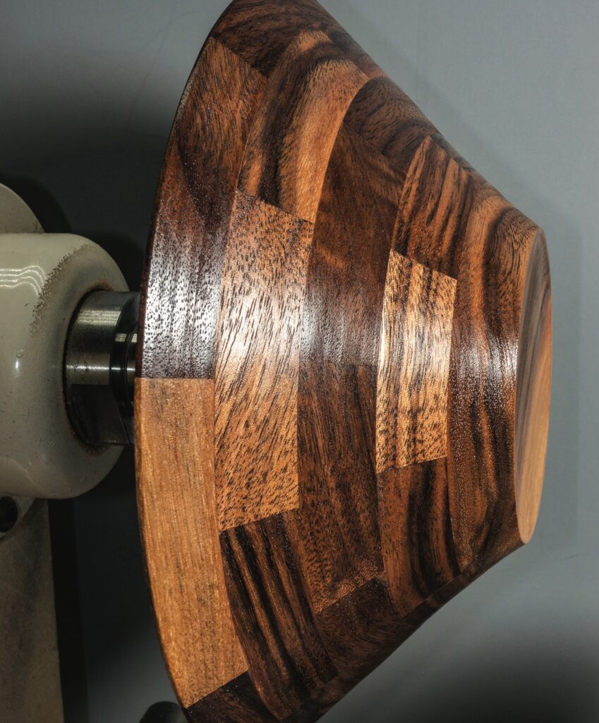 Wooden bowl on lathe, dark and light patterns.
