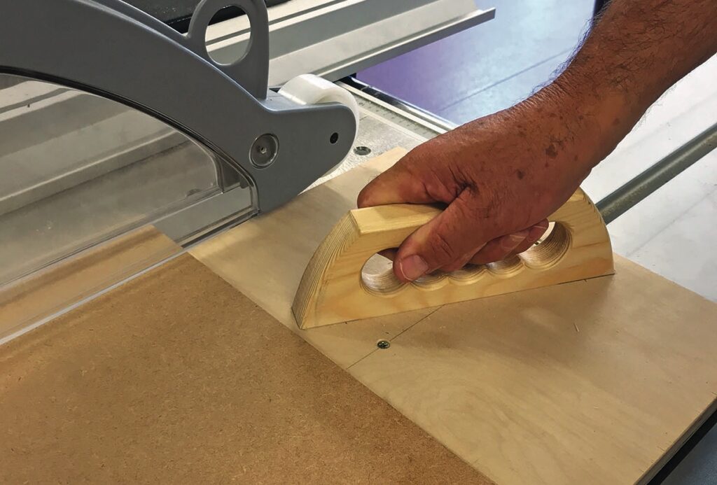 Hand guiding wood through a table saw
