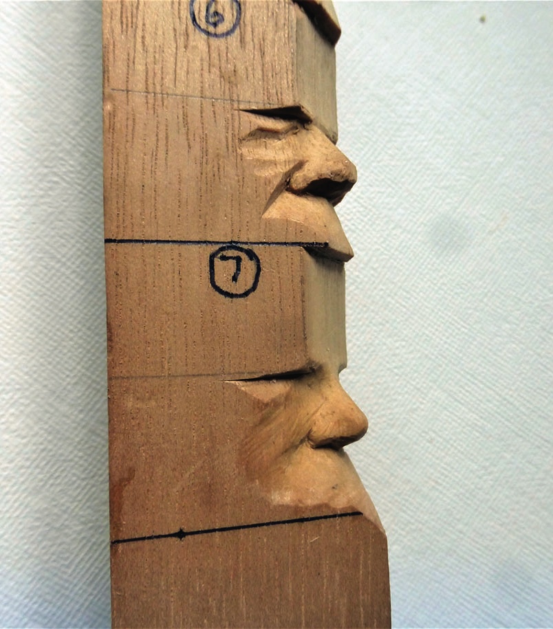 Wood carving featuring small detailed faces