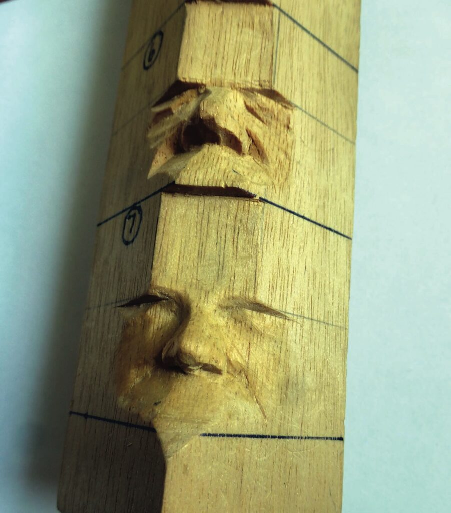 Wood stick carved with multiple faces.