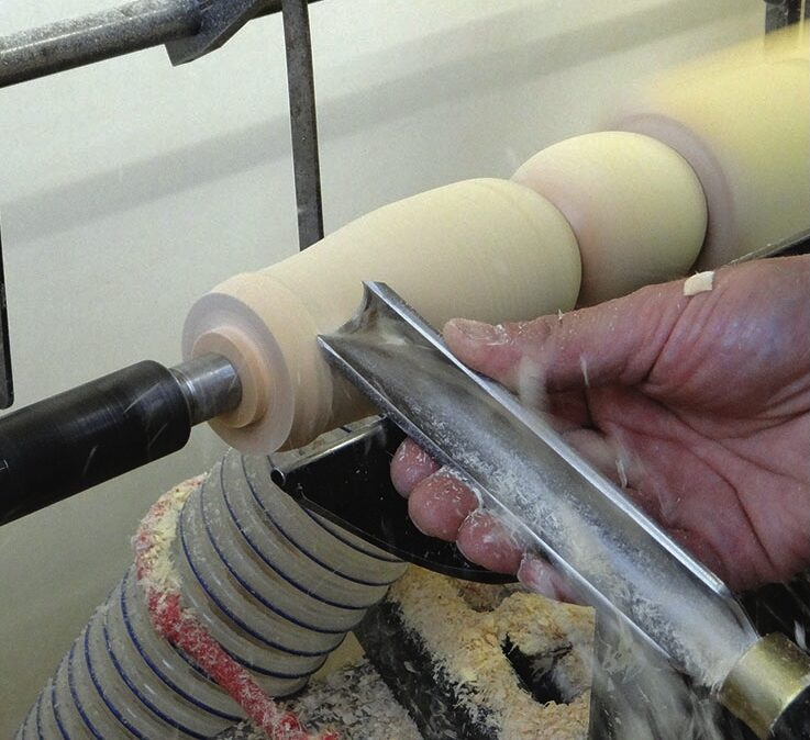 Woodturner shaping a spindle on a lathe