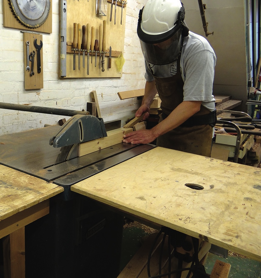 Woodworker using a table saw in workshop
