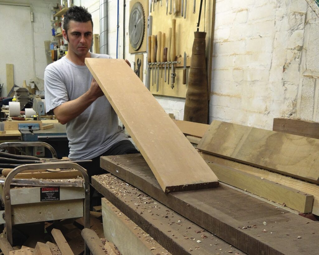 Woodworker inspecting a timber board in a workshop