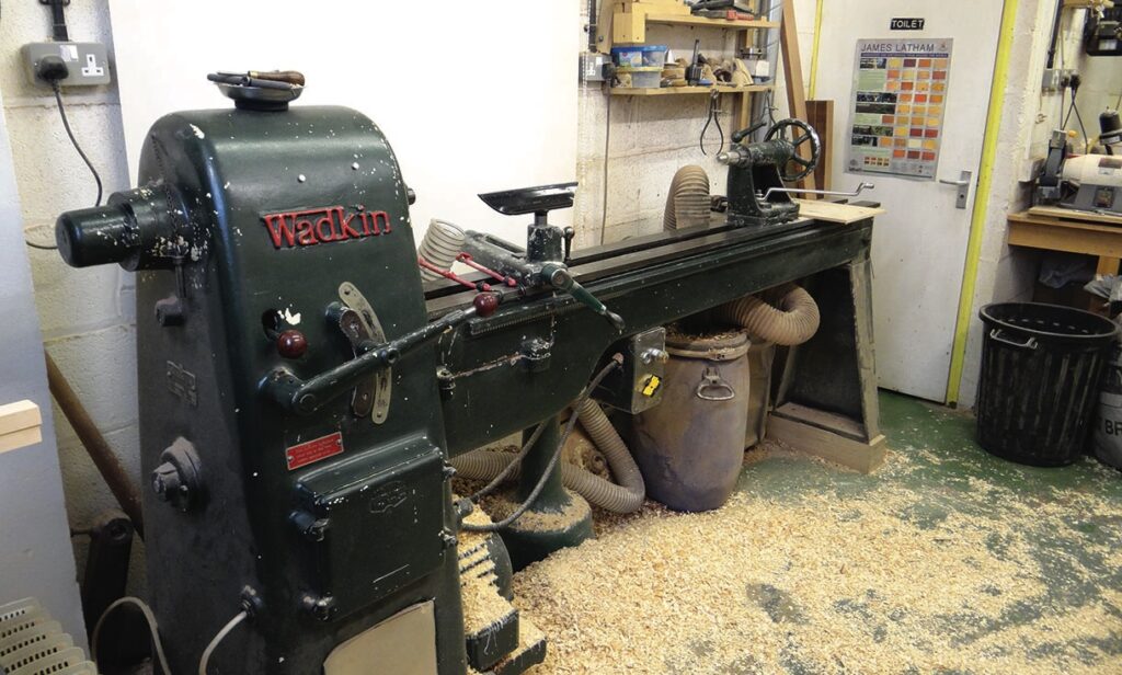 Vintage Wadkin wood lathe in a sawdust-covered workshop