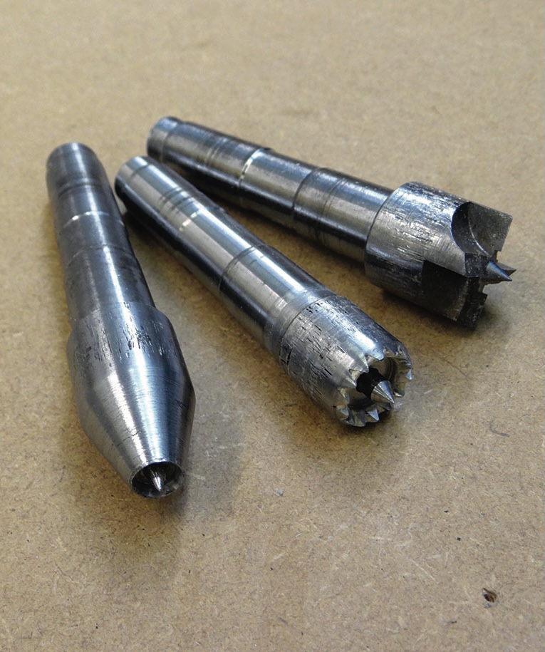 Three metal hole saw drill bits on workbench