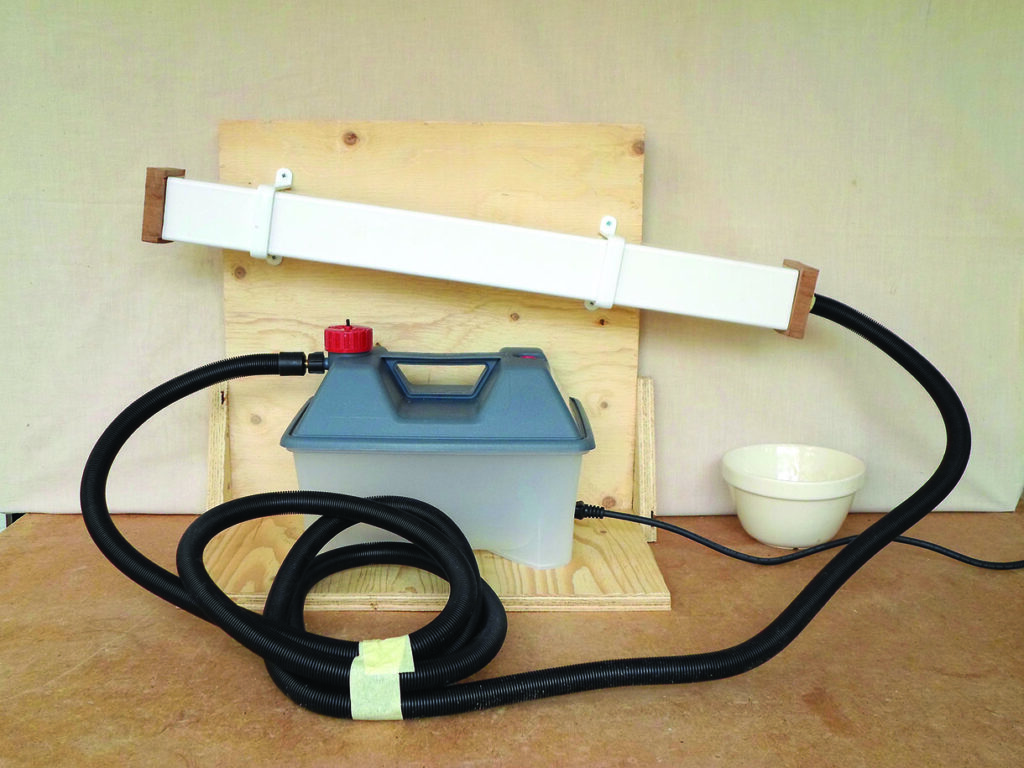 Homemade hose-connected apparatus mounted on a wooden board