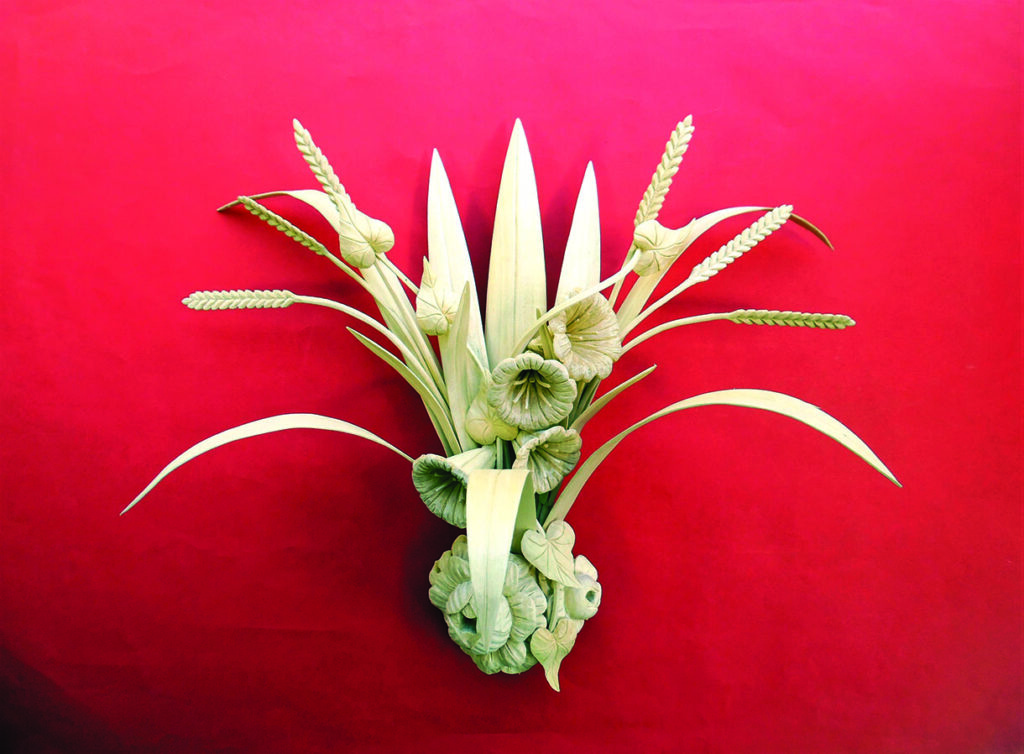 Intricate pale leaf and wheat arrangement on red background
