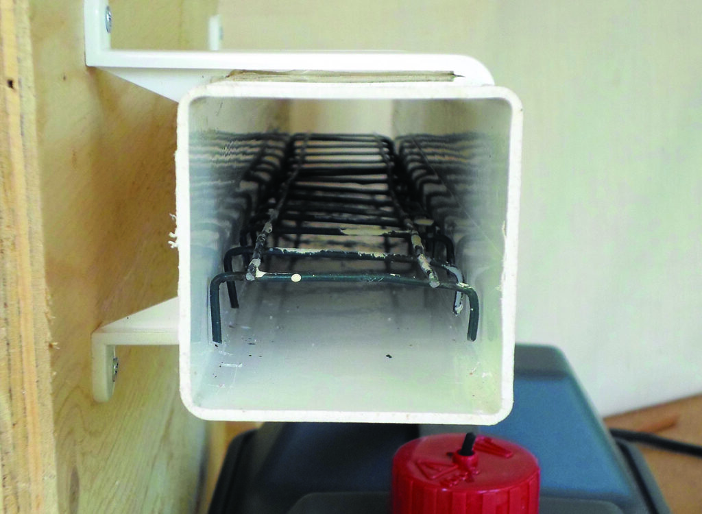Close-up of a heating element inside a square plastic duct