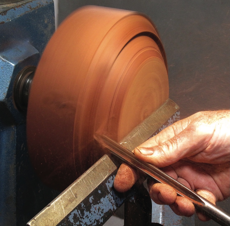 Woodturning on a lathe with hands crafting.