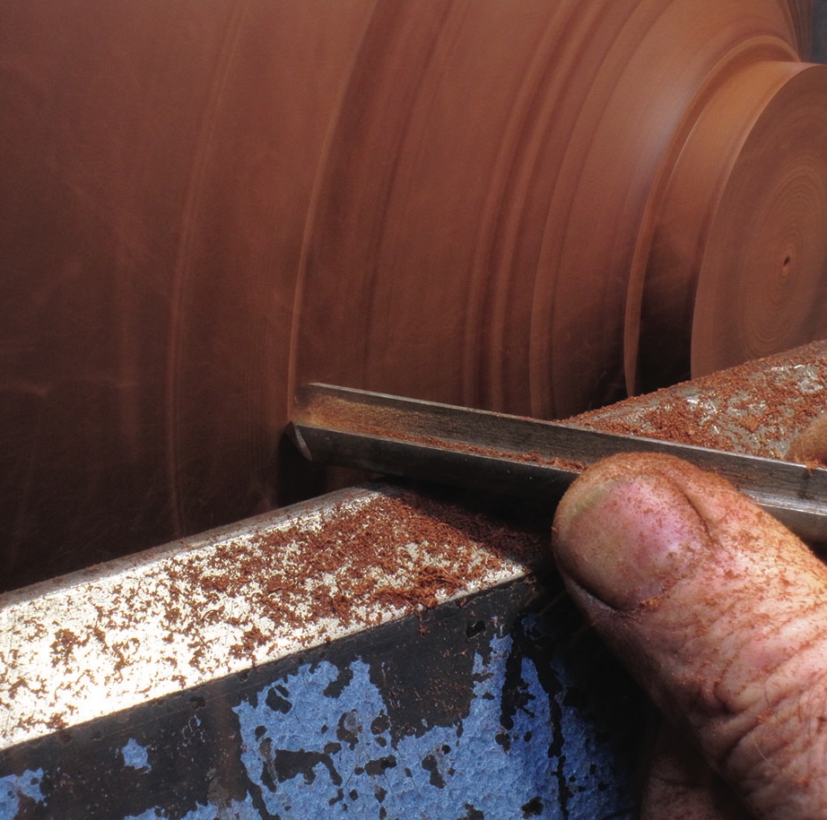 Woodturning with a lathe tool and spinning wood.