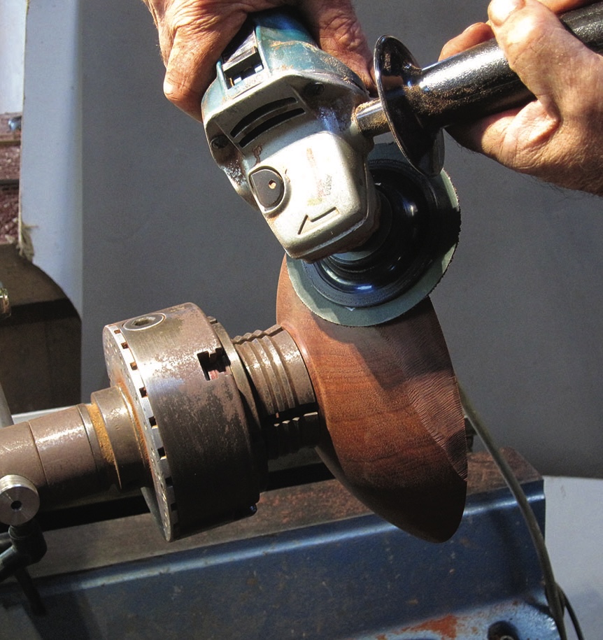 Woodturning with grinder on lathe machine.