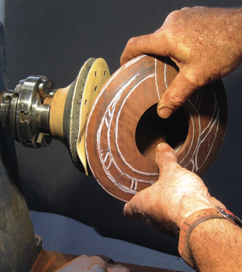 Craftsman shaping wooden bowl on lathe