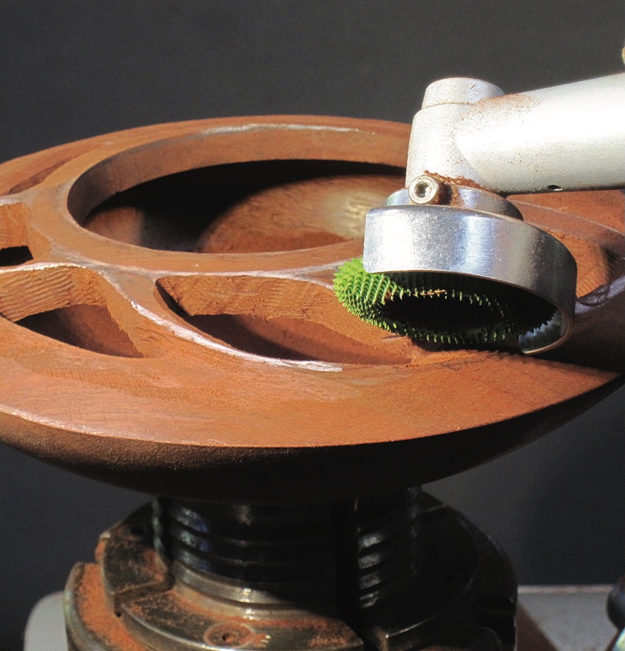 Robot arm cleaning wooden surface with brush