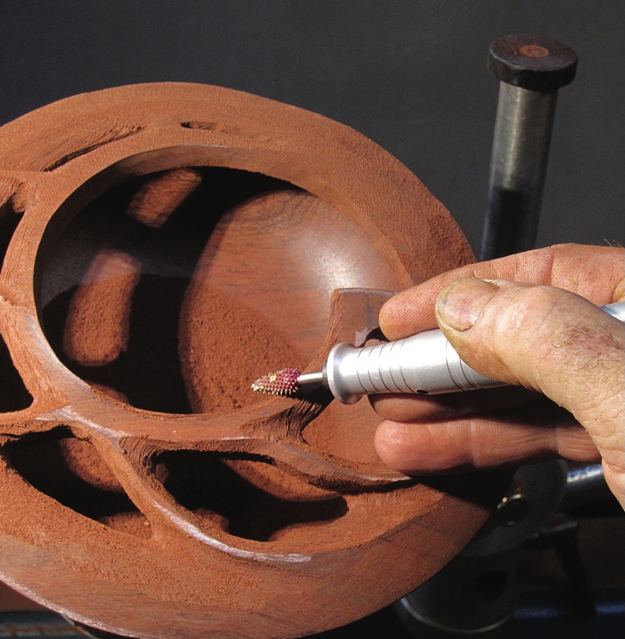Hand carving detailed wooden bowl with power tool.